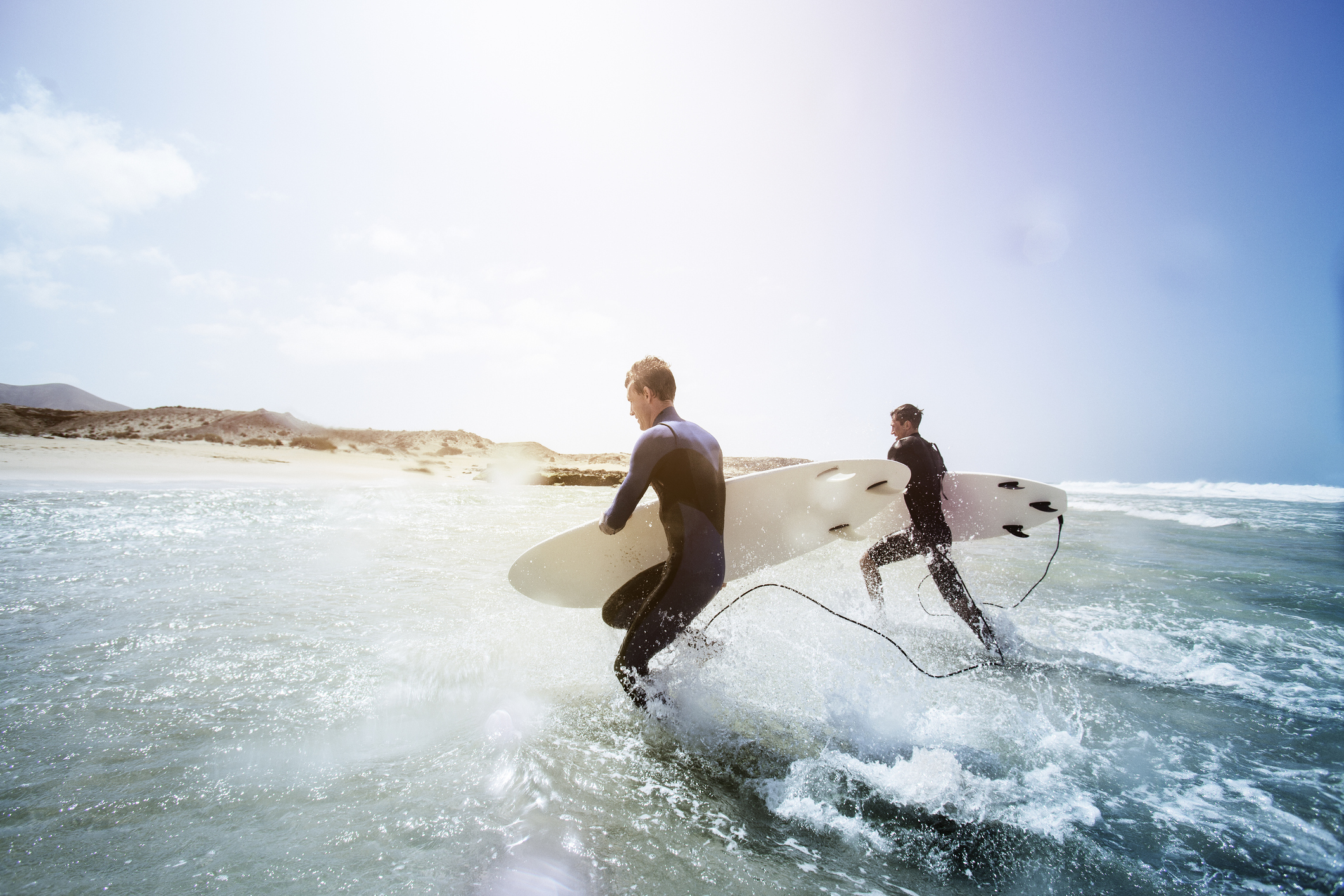 Surfers entering the Atlantic